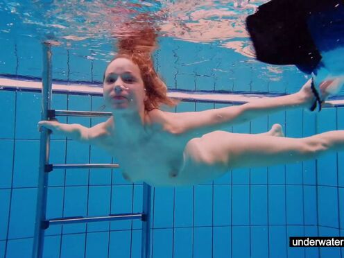 Ginger sexy girl swimming naked in the pool