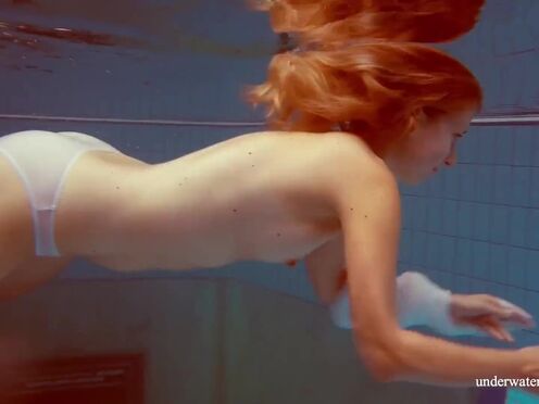 In the indoor pool, a mesmerizing babe swims