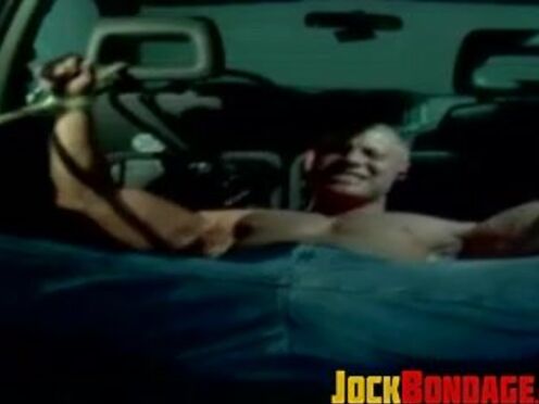 Muscle jock tied up with thick rope during outdoor BDSM